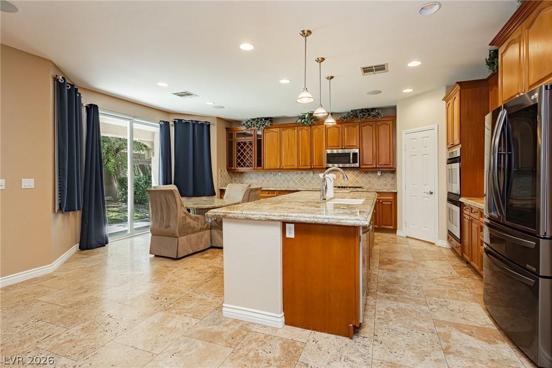 Image 3: A chef's kitchen features granite countertops, a c