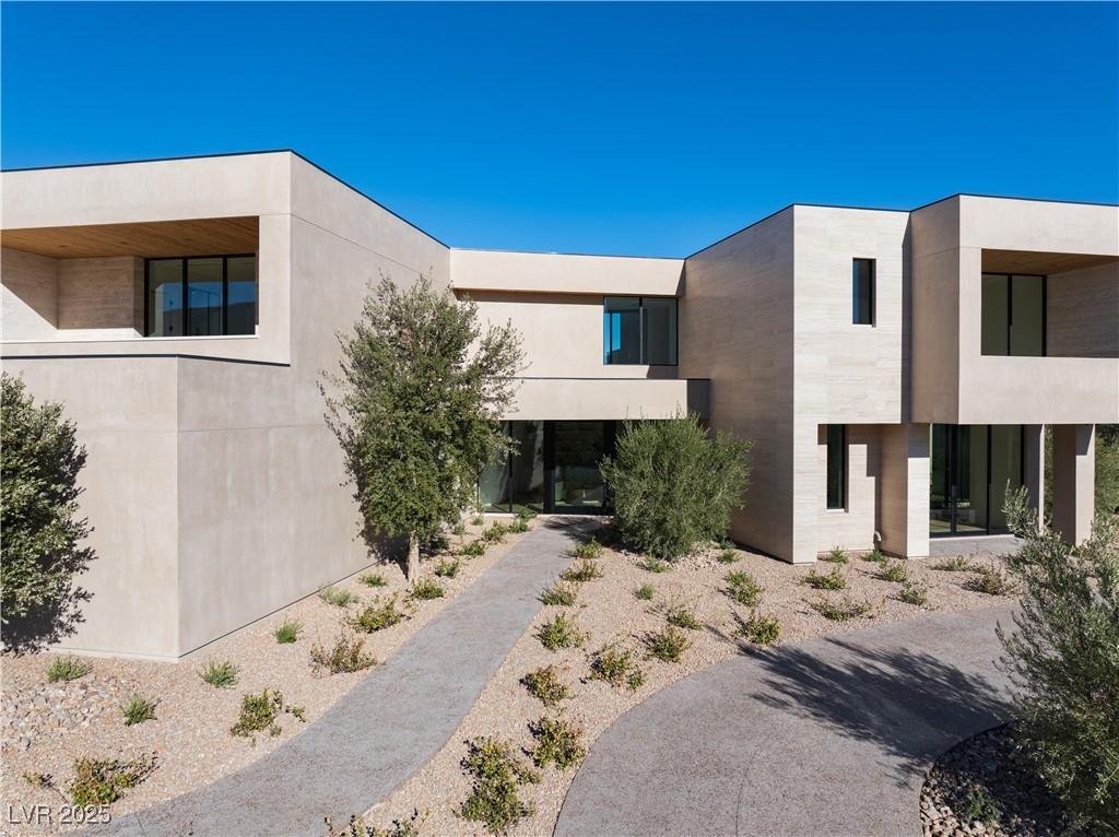 Image 2: View of front facade featuring stucco siding