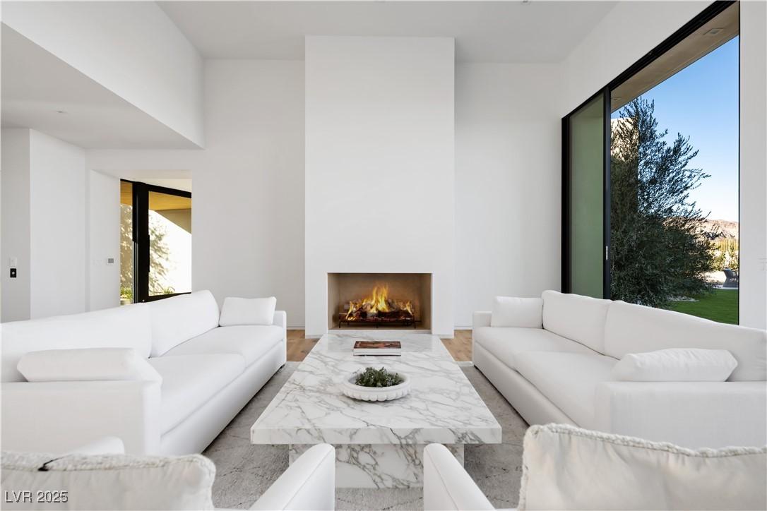 Image 4: Living area with a warm lit fireplace and wood fin