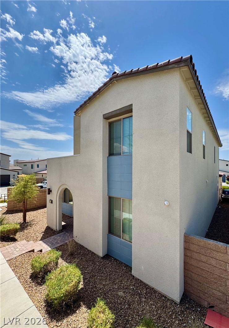 Image 2: A contemporary stucco home boasts a charming arche