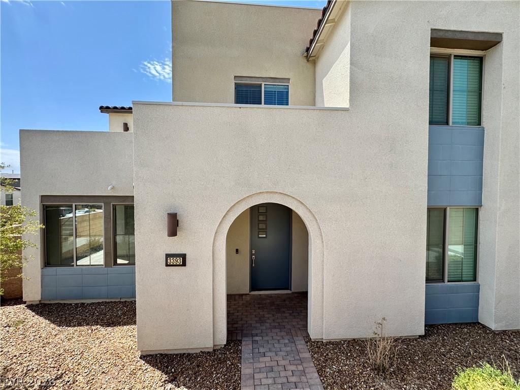 Image 3: An inviting arched entryway leads to this modern h