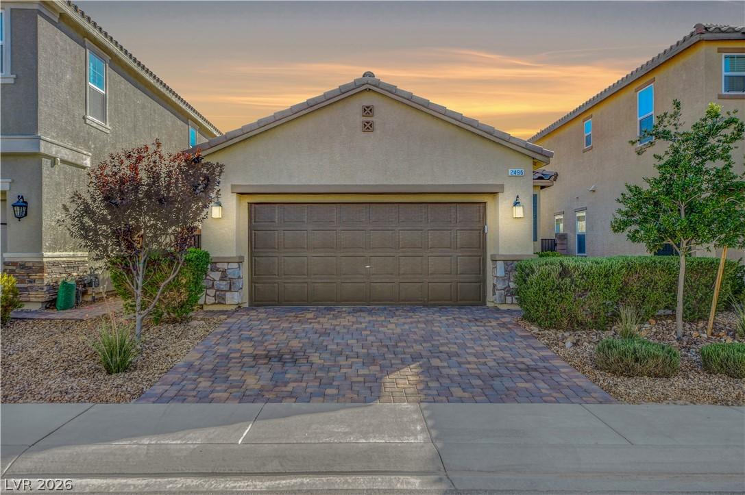 Image 2: A welcoming facade with a paver driveway, compleme