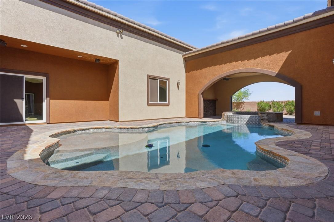 Image 3: An inviting backyard oasis offers a freeform pool