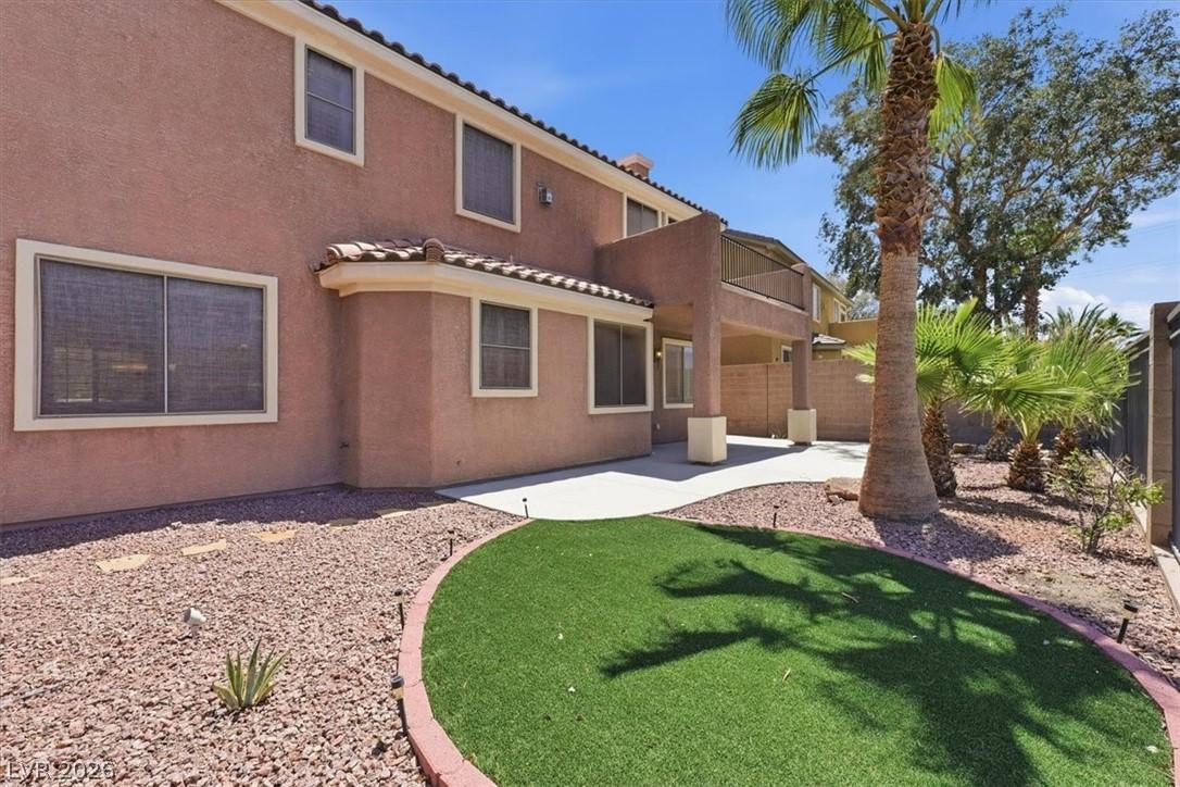 Image 3: An inviting backyard oasis offers a lush artificia