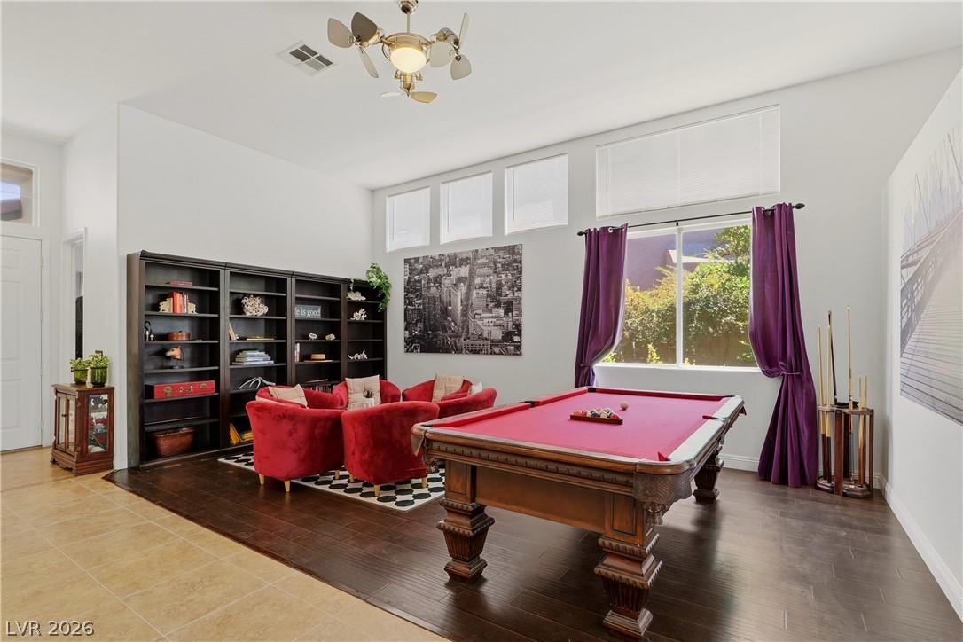 Image 4: A vibrant game room offers rich wood flooring and
