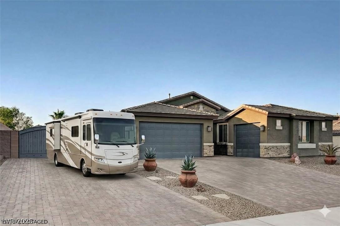Image 1: A broad paver driveway leads to a home with ample