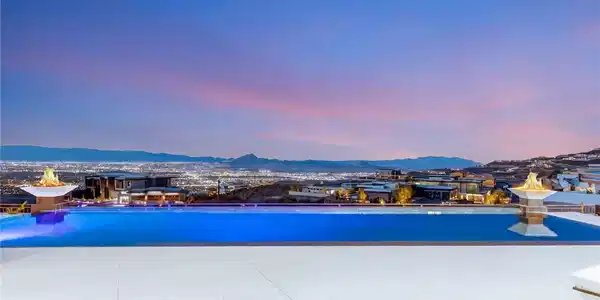Image 4: An infinity pool overlooks dramatic mountain and s