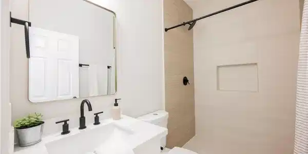 Image 3: Modern tile accents and a crisp white vanity defin