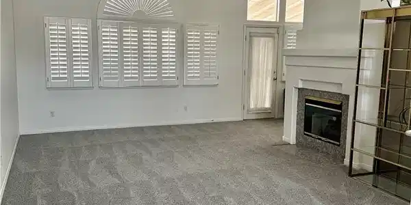 Image 2: A spacious living area features a classic fireplac