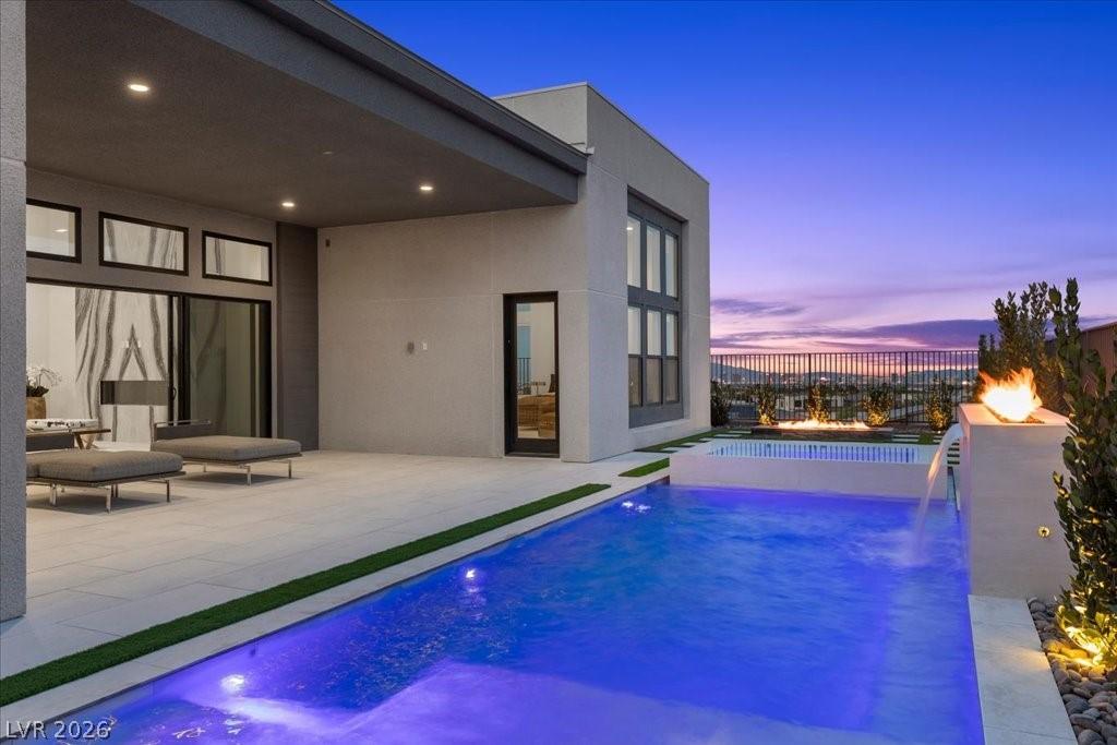 Image 2: An inviting pool area with a fire feature, offerin