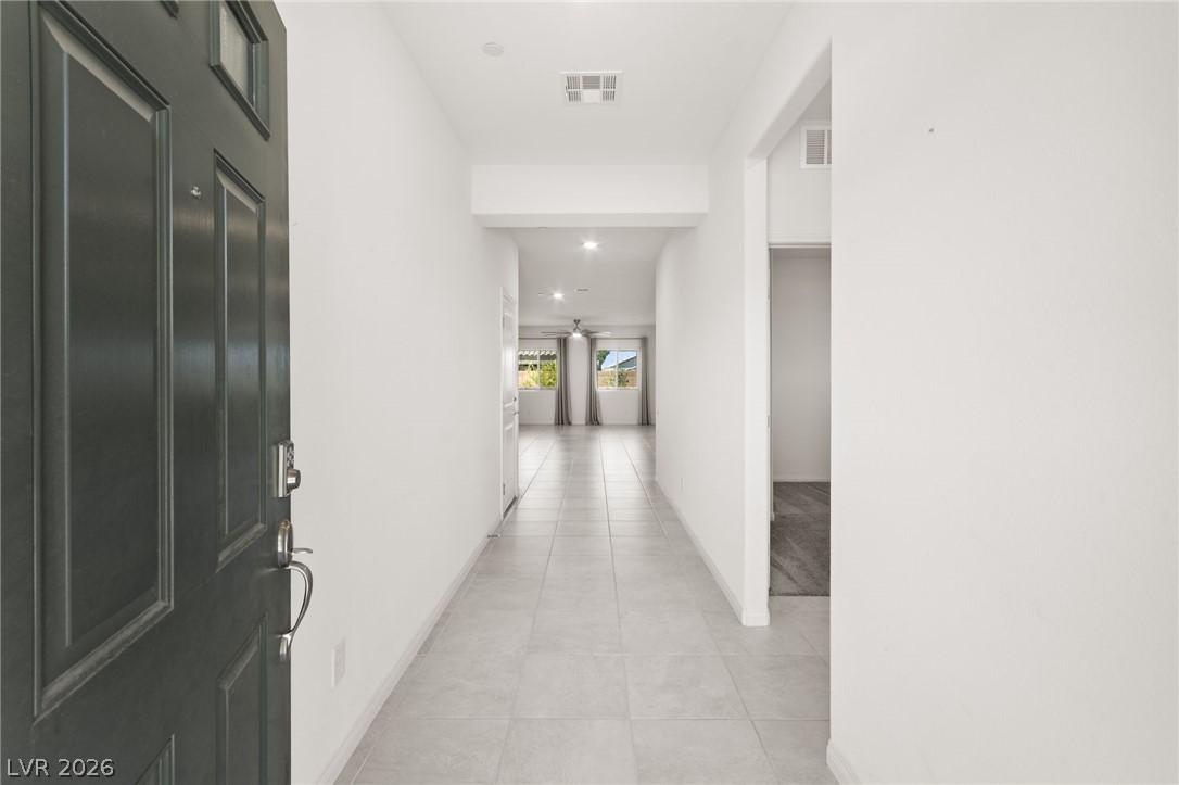 Image 4: A well-lit entry hall with tile flooring leads to