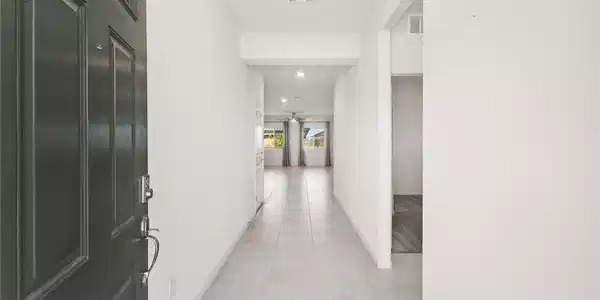 Image 4: A well-lit entry hall with tile flooring leads to