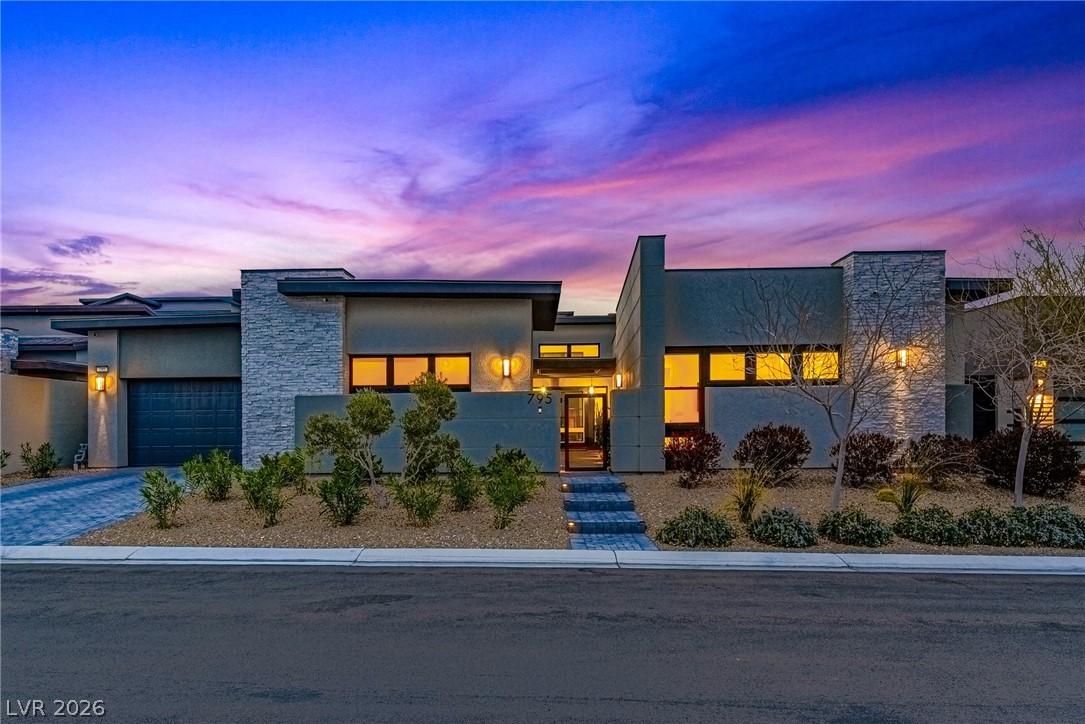 Image 2: View of front of house featuring stone siding, a g