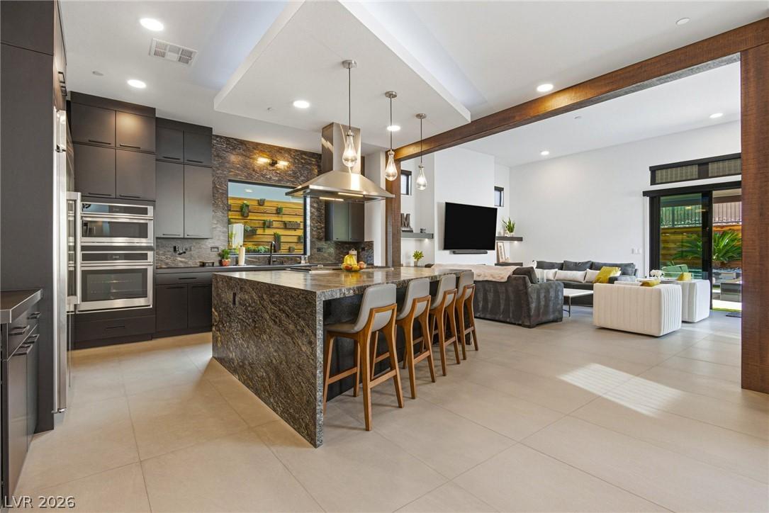Image 3: Kitchen with tasteful backsplash, a kitchen bar, b