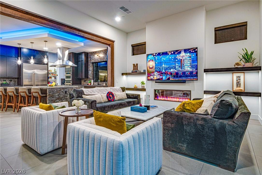 Image 4: Living area featuring a glass covered fireplace, l