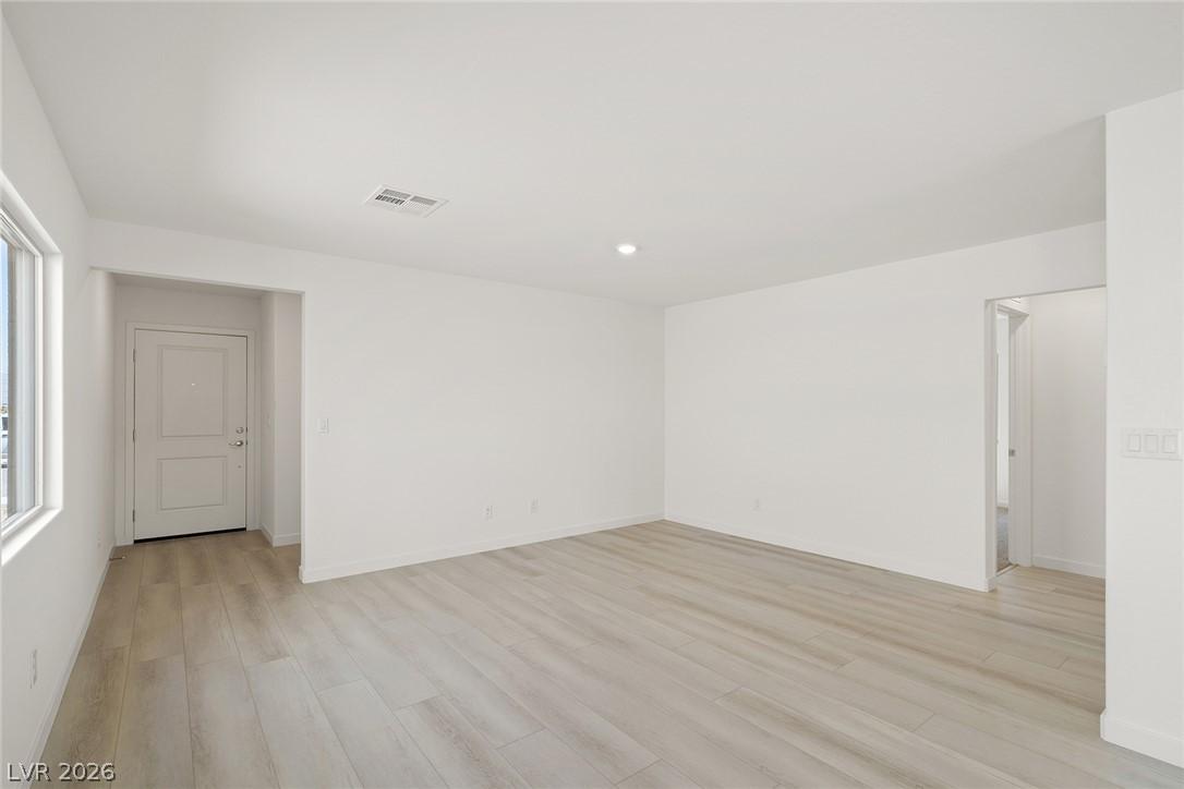 Image 3: A well-lit interior features wide-plank flooring a