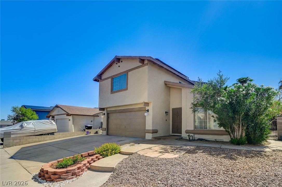 Image 1: A desert-friendly landscape greets this stucco res