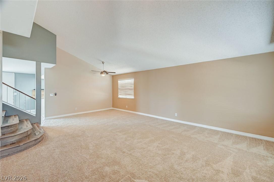 Image 2: A spacious living area features high vaulted ceili