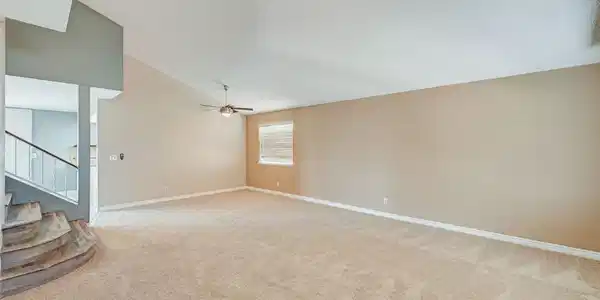 Image 2: A spacious living area features high vaulted ceili