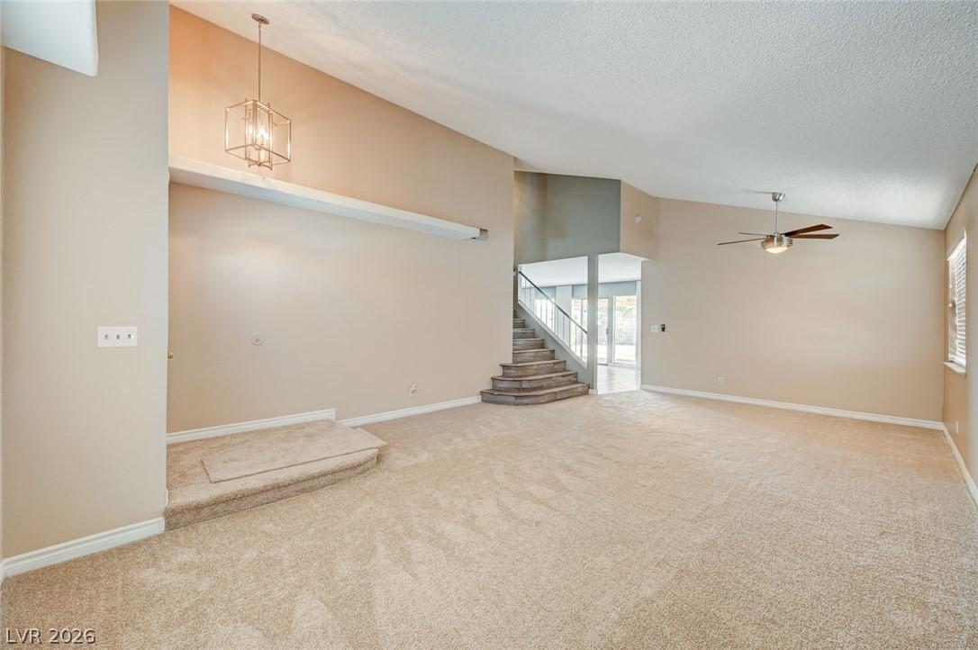 Image 3: A spacious living room featuring soaring vaulted c