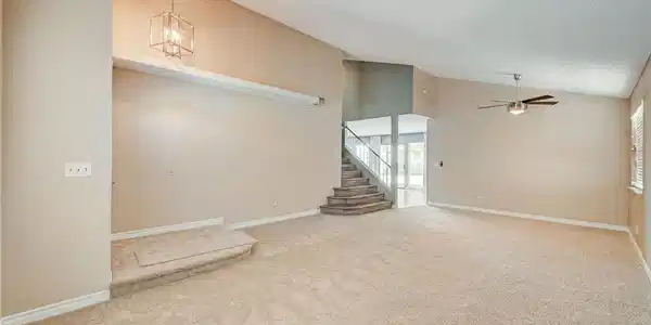 Image 3: A spacious living room featuring soaring vaulted c