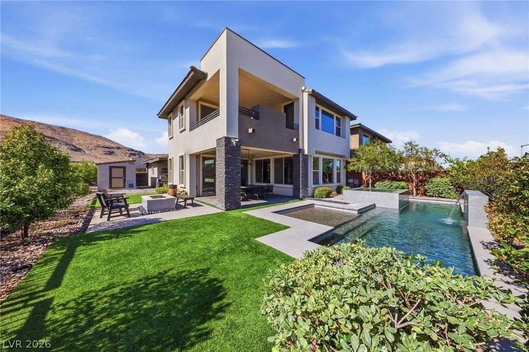 Image 1: A private backyard oasis features a shimmering poo