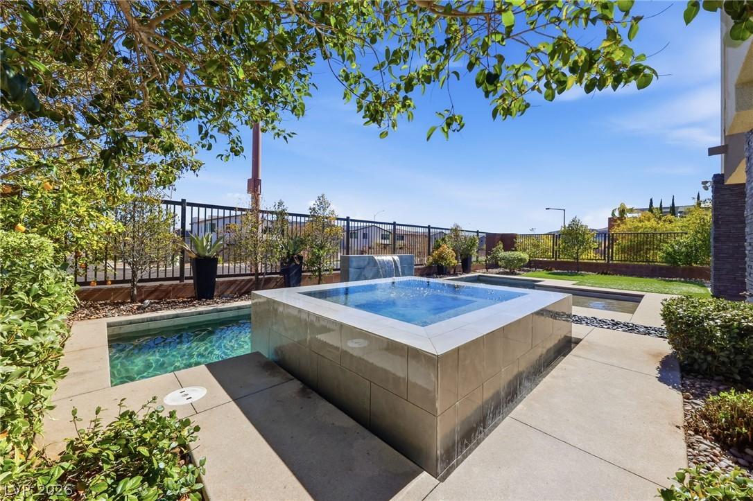 Image 2: A private backyard oasis features a shimmering poo