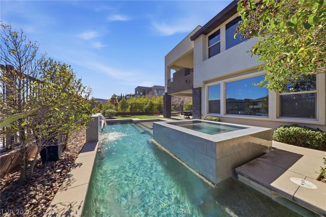 Image 3: A crystalline pool with a built-in spa complements