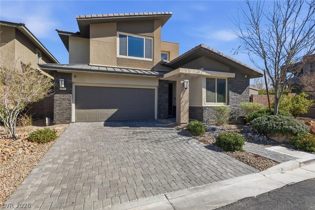 Image 4: Modern architecture with a paver driveway, offerin