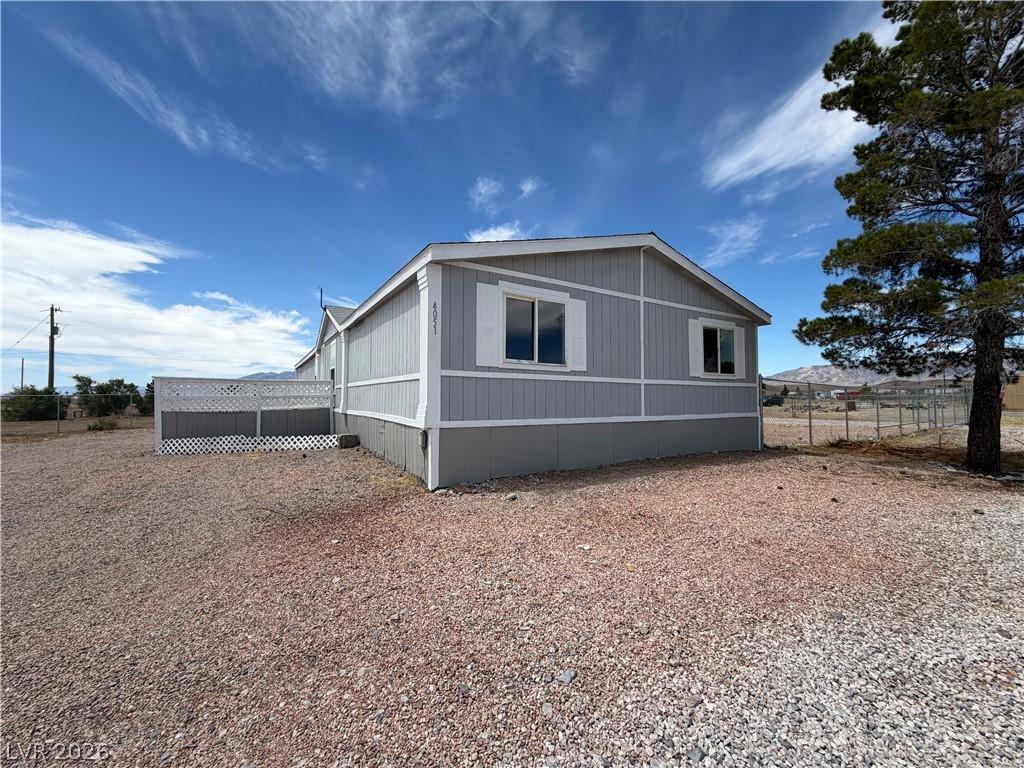 Image 3: A classic gray-sided residence sits upon a gravel
