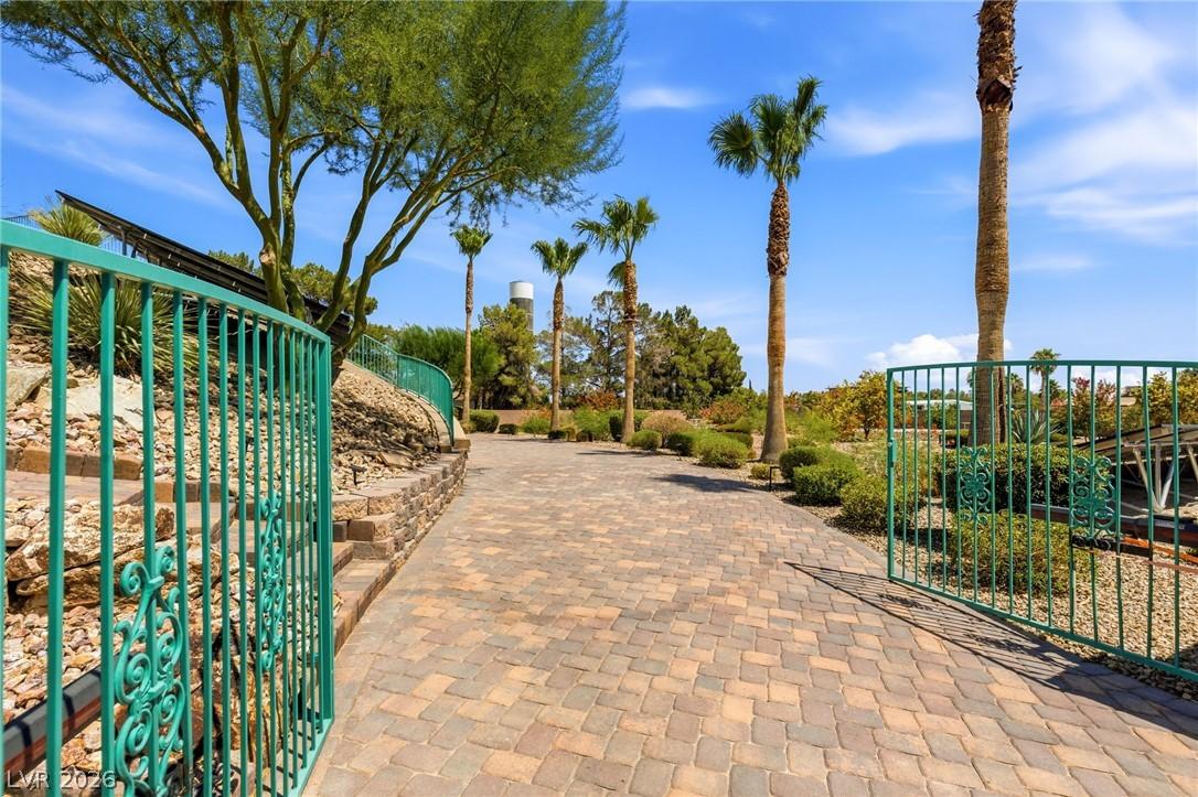 Image 4: A private, paver-lined driveway extends through a