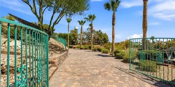 Image 4: A private, paver-lined driveway extends through a