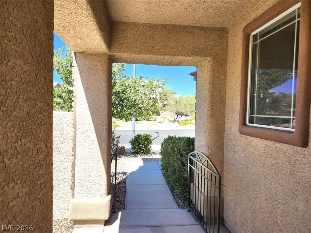 Image 4: A welcoming covered entry framed by stucco walls o