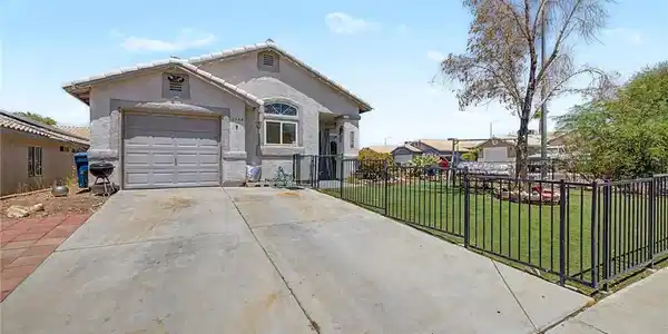 Image 2: A fenced front yard with mature landscaping enhanc
