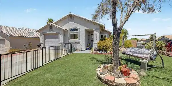 Image 3: Fenced front yard offers a charming swing beneath
