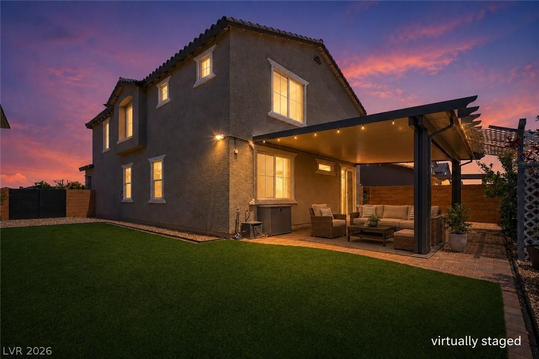 Image 3: An inviting covered patio and lush lawn define the