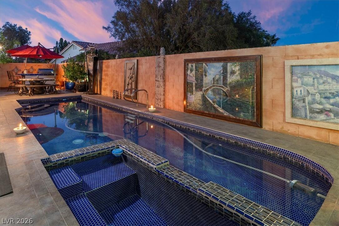 Image 2: An inviting backyard oasis features a shimmering p