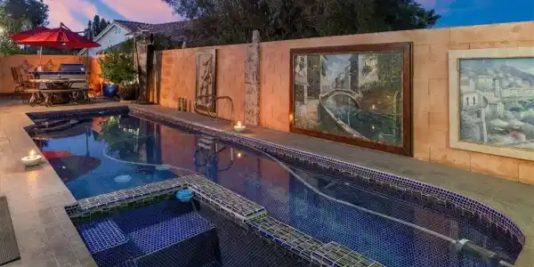Image 2: An inviting backyard oasis features a shimmering p