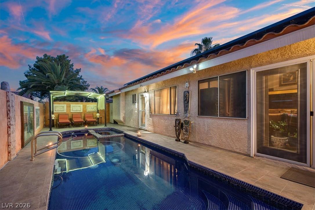 Image 3: An inviting backyard oasis offers a sparkling pool