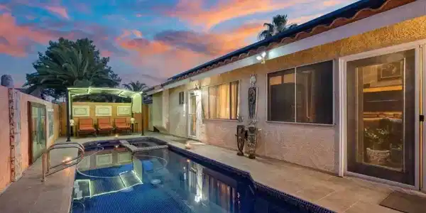 Image 3: An inviting backyard oasis offers a sparkling pool