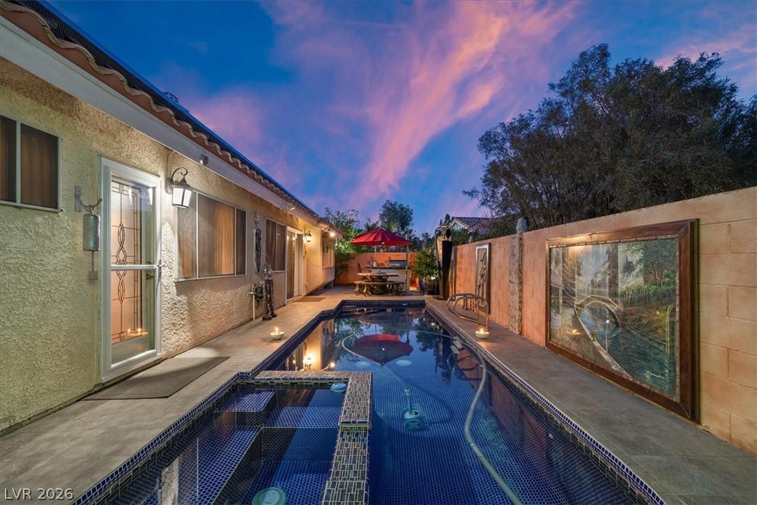 Image 4: An inviting backyard oasis features a shimmering p