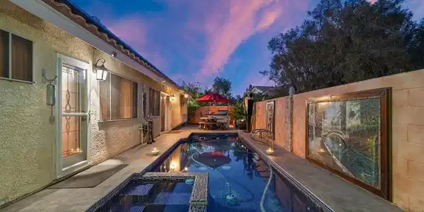 Image 4: An inviting backyard oasis features a shimmering p