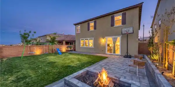 Image 2: This outdoor space offers a paved patio, lush lawn