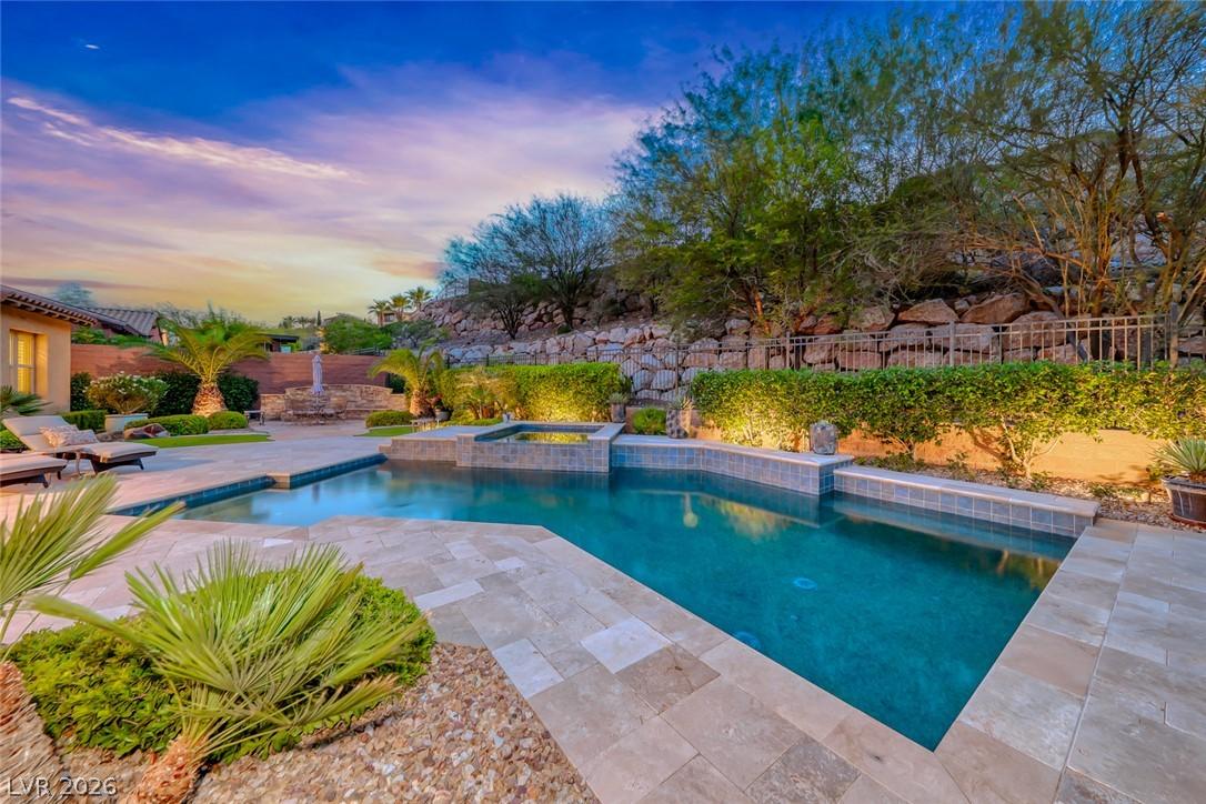 Image 2: An inviting backyard oasis features a custom pool,