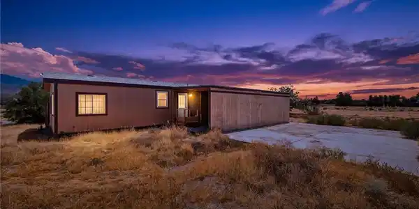 Image 2: A manufactured home sits against a vivid twilight