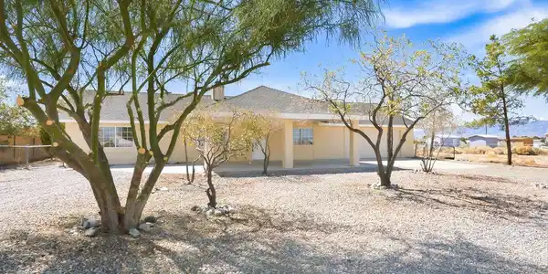 Image 2: Fenced side yard features low-maintenance gravel l