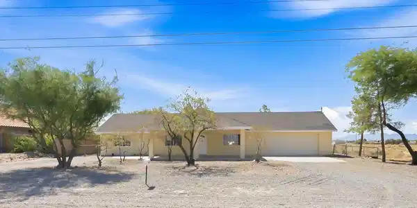 Image 3: Mature trees shade a low-maintenance gravel yard u