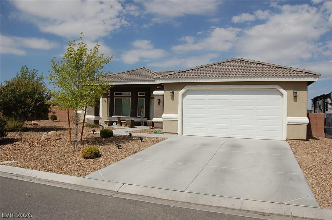 Image 1: Well-maintained desert landscaping frames a reside
