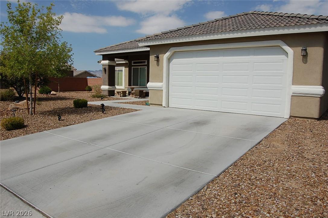 Image 2: A well-maintained stucco home with a concrete driv