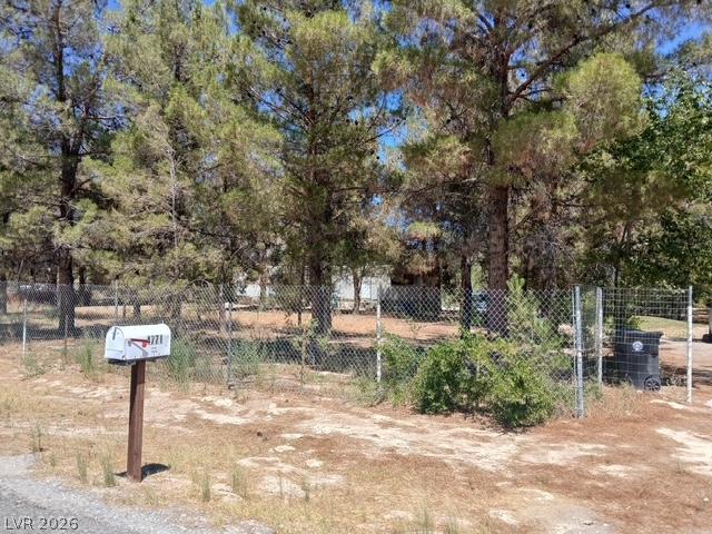 Image 3: Chain link fencing borders this generously treed l